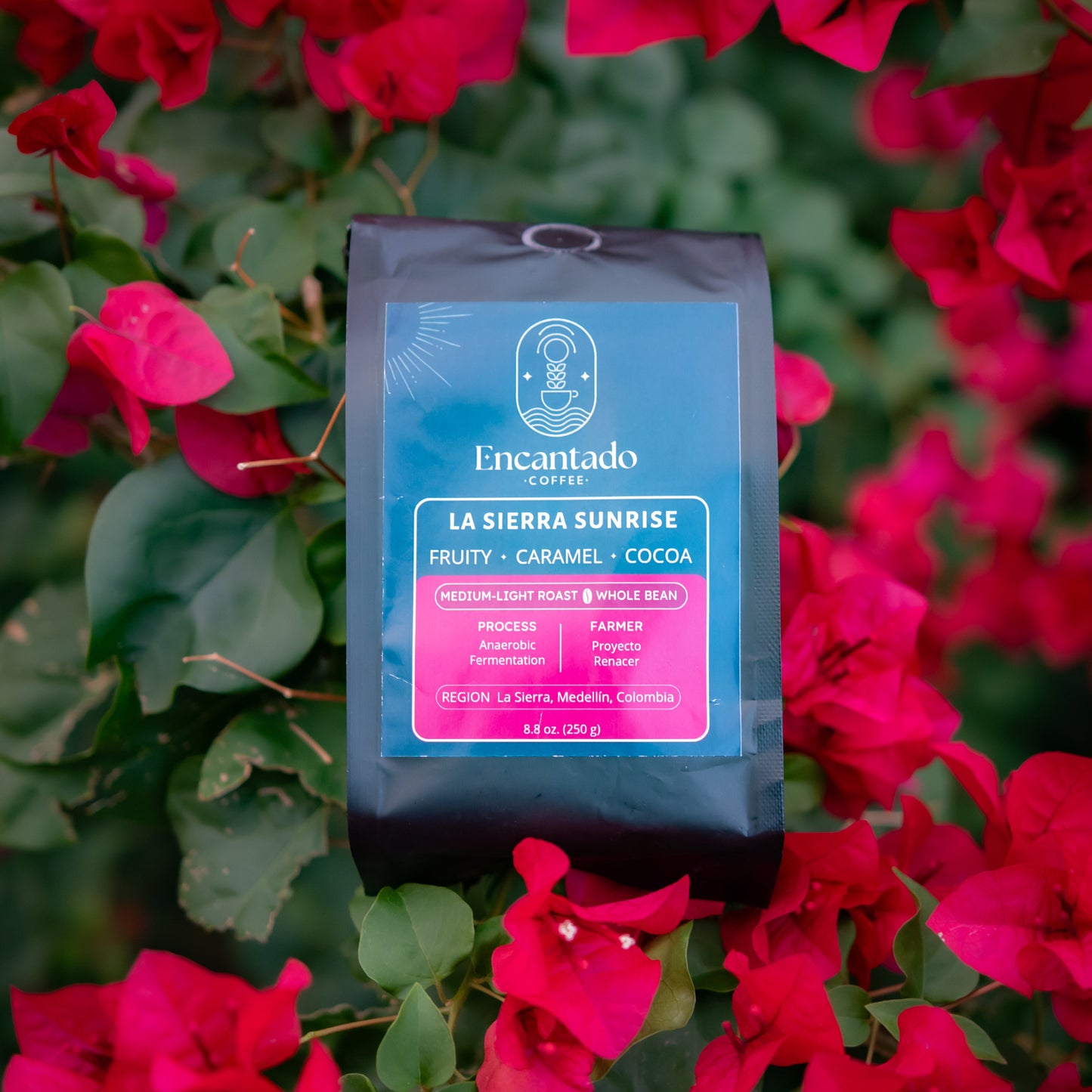 Encantado coffee bag with 'La Sierra Sunrise' flavor on a background of red flowers